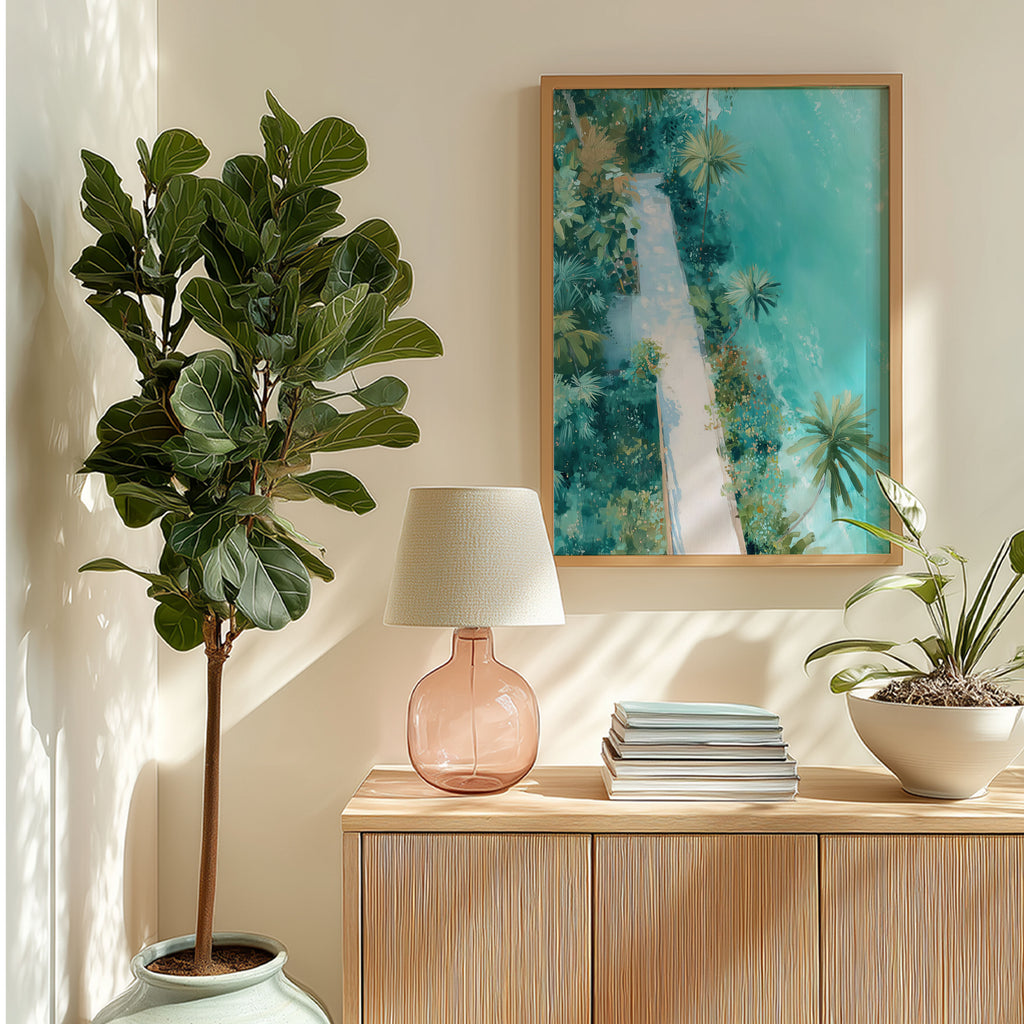 Decorative interior with a potted plant, lamp, books, and artwork on a wall.